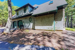 Ein zweistöckiges Haus mit Garage, überdachter Veranda und Natursteinfundament.