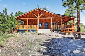 Un chalet en bois doté d’une véranda, d’une porte et d’une fenêtre.