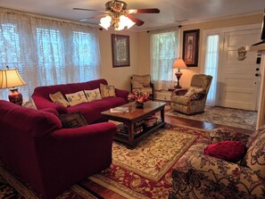 A living room with a red sofa, a wooden coffee table, and a patterned rug.