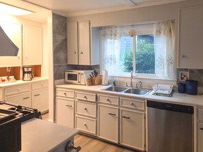 A kitchen with a microwave, sink, and cabinets.