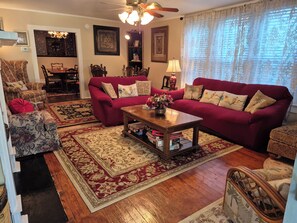 A living room with a red sofa, a wooden coffee table, and a patterned rug.