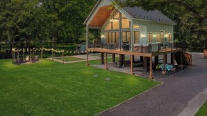 A two-story house with a deck, a fire pit, and a covered outdoor seating area. - River Run - Riverfront+Pickleball+Hot Tub+Sauna (Shenandoah)