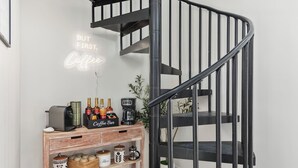 A staircase with a neon sign reading 'BUT FIRST Coffee' and a coffee bar with various items. - River Run - Riverfront+Pickleball+Hot Tub+Sauna (Shenandoah)
