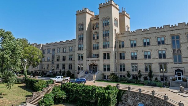 Un edificio grande y antiguo con múltiples torres y una entrada central.
