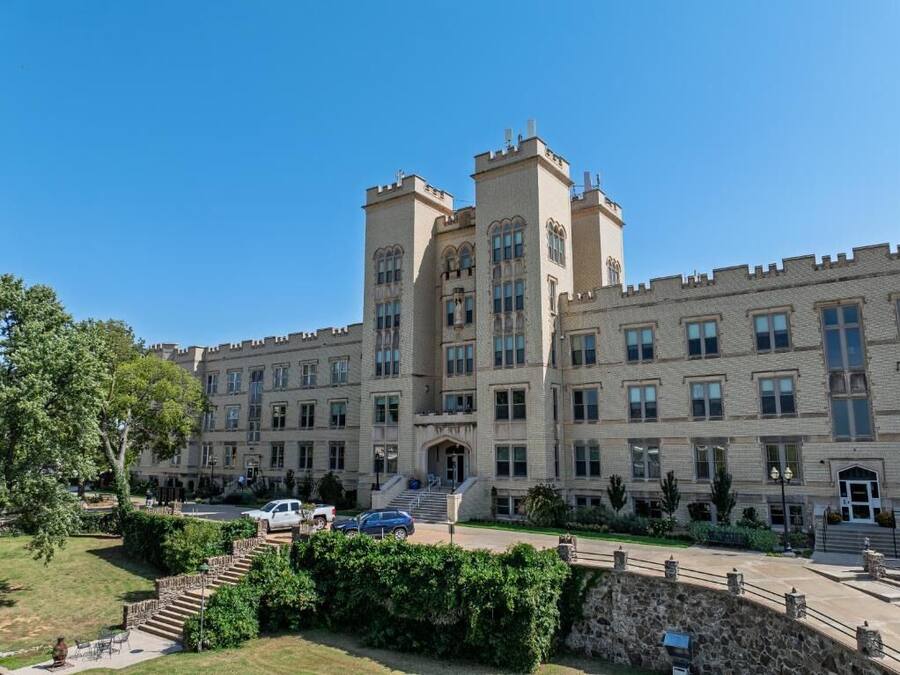 A large, historic building with multiple towers and a central entrance.