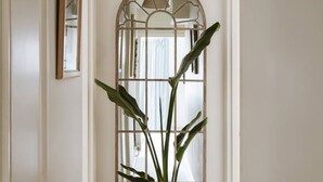 A hallway with a potted plant, a door with a brass handle, and a framed picture on the wall. - Colourful house 2 bedroom Apt - Notting Hill (Greater London)