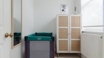 A child's playpen, a wardrobe, a mirror, and a window with a view.