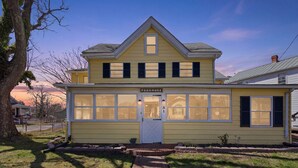 A yellow two-story building with a white door and windows, labeled 'POGOMOKE.' - Charming 6BR Colonial Beach Retreat, Walk to the Beach (Colonial Beach)
