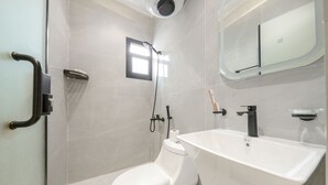 A modern bathroom with a toilet, shower, sink, and a small window. - Furnished Studio in Al-Aqiq (Riyadh)