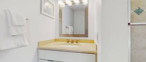 A bathroom with a sink, mirror, and towel rack.