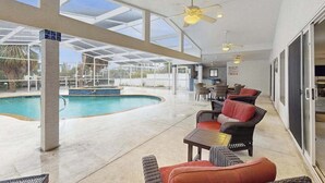 Ein Poolbereich mit Sitzgelegenheiten, Deckenventilatoren und Blick auf den Pool.
