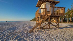 A wooden lifeguard tower on a sandy beach with clear skies. - Updated bayside condo with heated pool - across the street from the beach (Anna Maria)