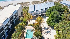 Un resort con piscina, vista sulla spiaggia e diversi edifici.