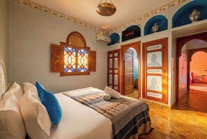Une chambre d’hôtel avec un lit, un climatiseur fixé au mur, un logo Netflix et un vitrail.