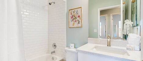Un baño con bañera, inodoro y lavabo.