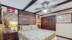 Een slaapkamer met een bed, een wereldbol, een kaart en een plafondventilator.