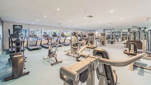 Een fitnessruimte met loopbanden, elliptische trainers en gewichten.