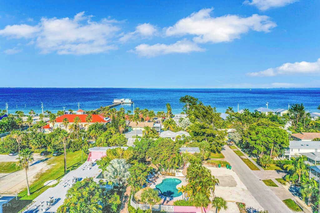 A coastal resort with a swimming pool, beachfront properties, and a pier.