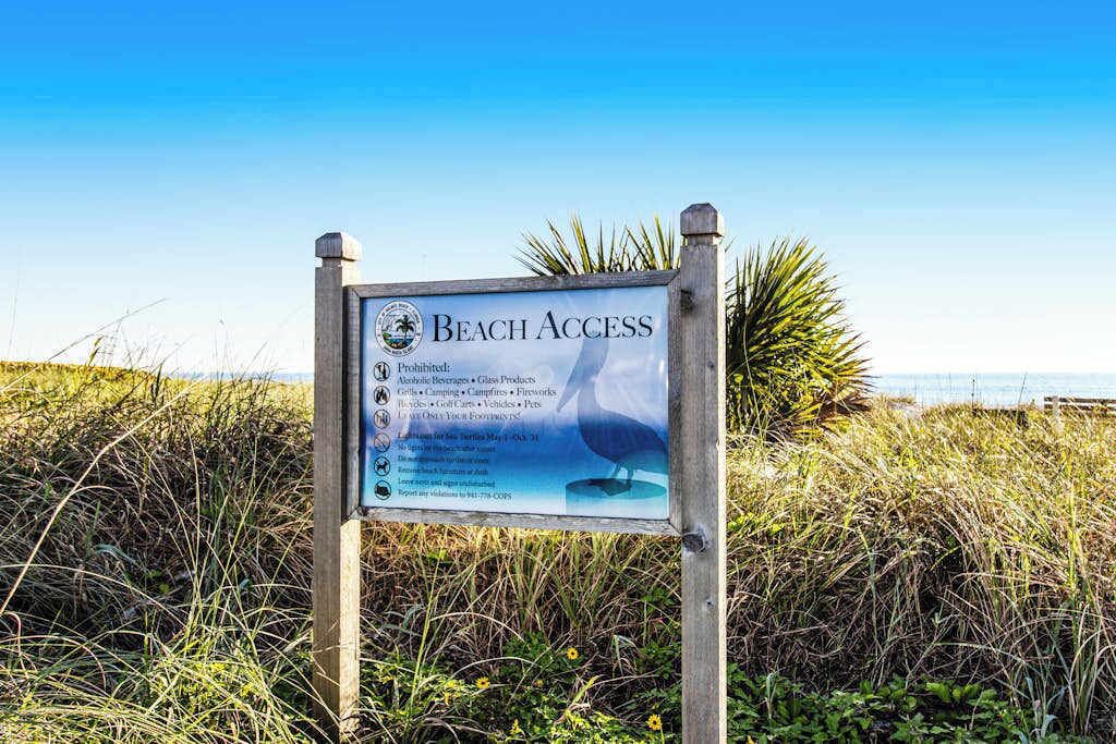 A beach access sign with a list of prohibited items.