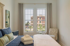 A hotel room with a bed, a chair, a desk, and a window with curtains. - The Current 331 - Just Redecorated Spacious Condo - Sleeps 8 (Inlet Beach)