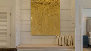 Ein Zimmer mit einer Bank, einem Wandbild und einer Tür.