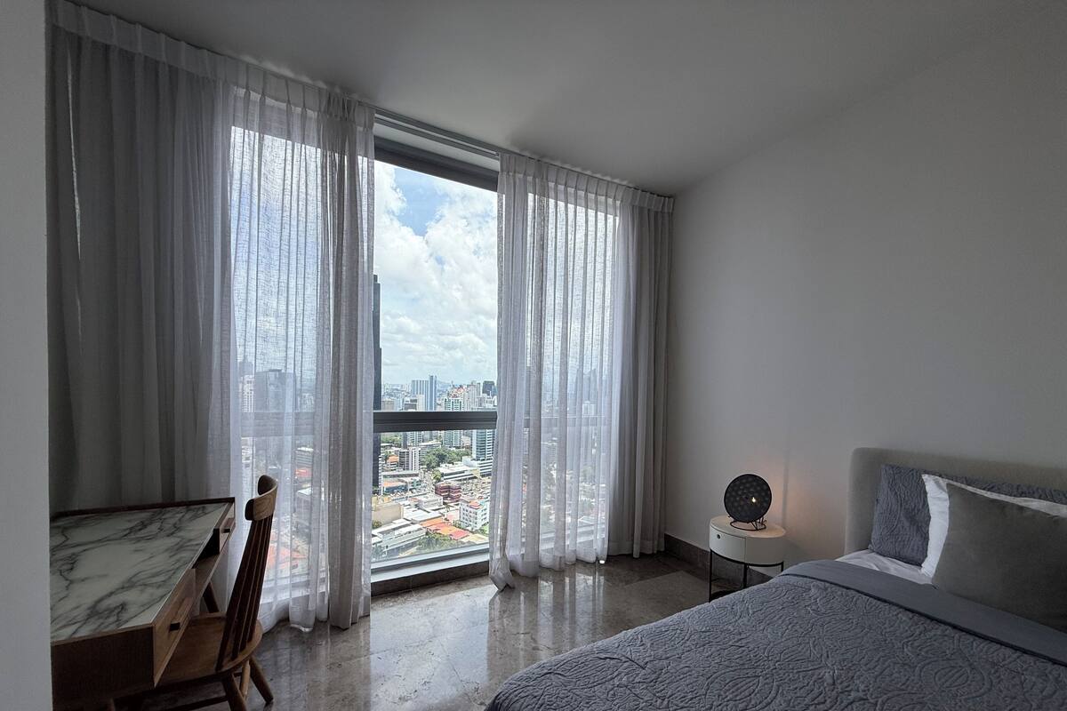 A hotel room with a bed, a desk, and a chair.