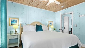 A bedroom with a bed, two bedside tables, a ceiling fan, and a door. - Charming Suite w Shared Pool, High-Speed WiFi - Steps to the Beach (Siesta Key)