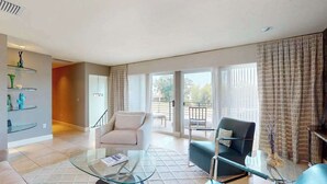 A spacious living room with a glass coffee table, two sofas, a staircase, and a balcony with a view. - Luxe bay-view escape with private pool, kayak, grill, ice box, & all-new interior (Sarasota)