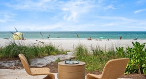 A beach view with a fenced area, chairs, and a barrel. - Luxury oceanfront home w/ pool, spa, free parking (Holmes Beach)