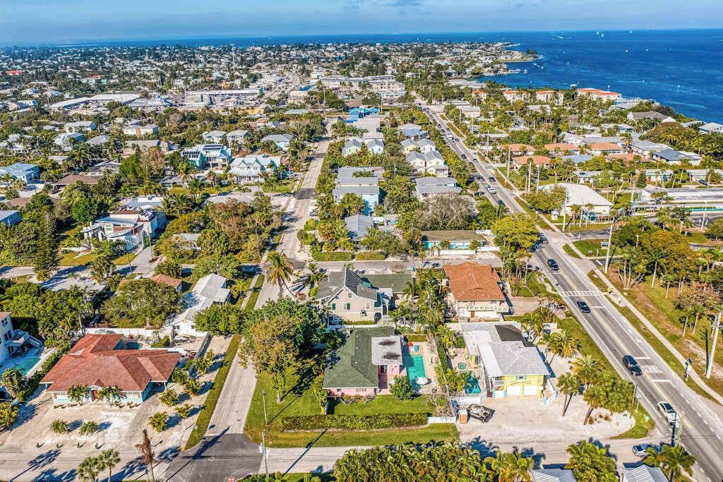Vista aérea de una zona residencial con casas, calles y una costa.