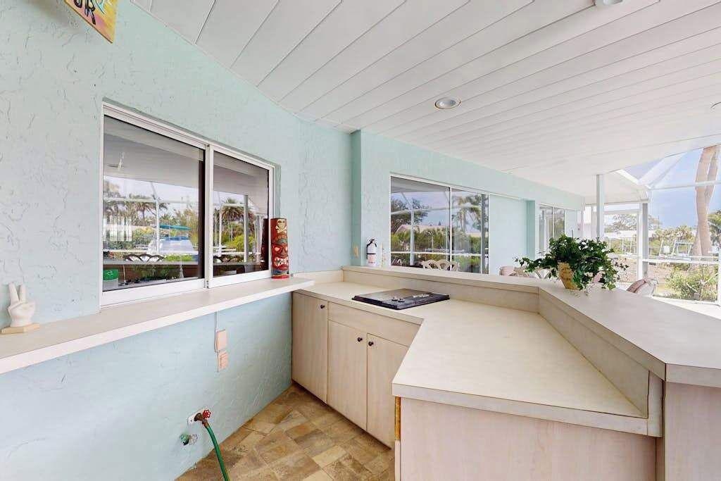 A modern kitchen with a large window, a countertop, and a sink.