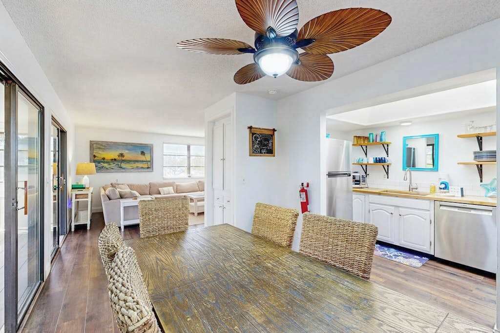 A modern kitchen with white cabinets, a stainless steel refrigerator, and a countertop with various items.