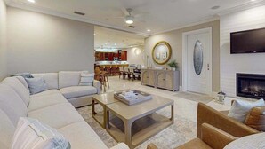 A modern living room with a sectional sofa, a coffee table, and a fireplace. - Oceanview getaway with pool & private patio - steps from the beach (Holmes Beach)