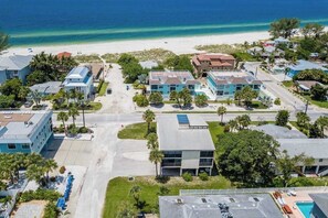 An aerial view of a coastal residential area with buildings, a beach, and a clear sky. - Contemporary dog-friendly home with shared pool - two blocks from the beach (Holmes Beach)