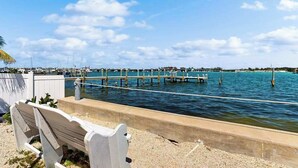A waterfront view with a dock, a bench, and a clear sky. - 2nd-floor condo with heated pool - walk to beach & Bridge Street (Bradenton Beach)