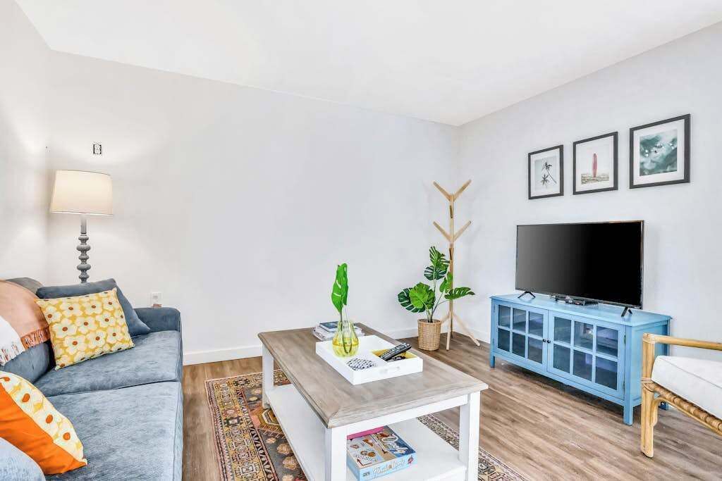 A living room with a sofa, coffee table, TV, and a cabinet.