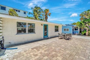 Ein Haus mit Terrasse, einer Tür und einem Fenster.