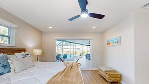 A bedroom with a bed, a ceiling fan, a window, and a view of an outdoor area. - Beautiful home with private pool and space for the whole family (Sarasota)