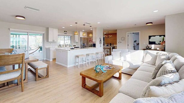A spacious living area with a sofa, coffee table, and dining area. - Beautiful home with private pool and space for the whole family (Sarasota)