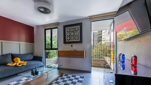 A modern living room with a sofa, glass coffee table, checkered rug, framed artwork, and a TV on a wall. - Accommodation in Condesa with a balcony, within walking distance of Roma (Ciudad de México)