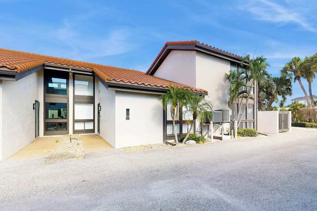Et moderne hus med to etager, tegltag, store vinduer og en indkørsel.
