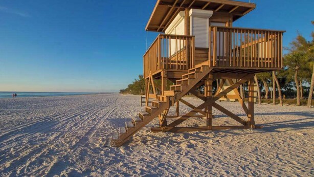 A wooden lifeguard tower on a sandy beach with clear skies. - Oceanfront condo with WiFi, & ocean views, walk to free trolley (Bradenton Beach)