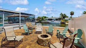 A rooftop patio with outdoor seating, a fire pit, and a view of the marina. - Waterfront home with private, heating optional pool, lanai, and internet (Bradenton)
