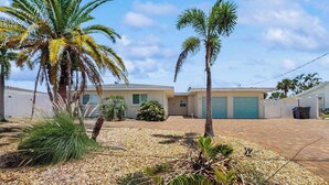 A residential area with a house, palm trees, and a gravel driveway. - Waterfront home with private, heating optional pool, lanai, and internet (Bradenton)