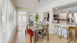 A modern kitchen with a dining area, a bar stool, and a plant. - Waterfront home with private, heating optional pool, lanai, and internet (Bradenton)