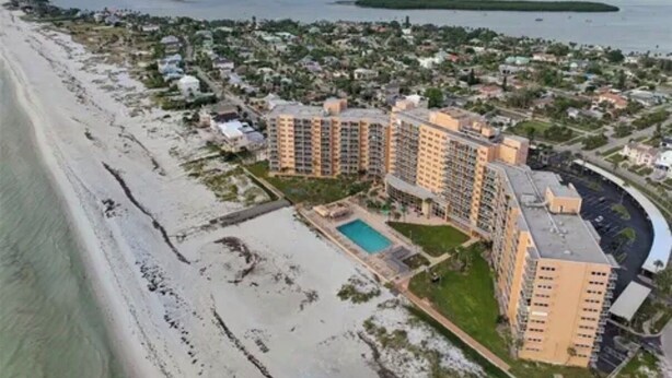 Ein Küstenhotel mit mehreren Gebäuden, einem Schwimmbad und einem Strand.