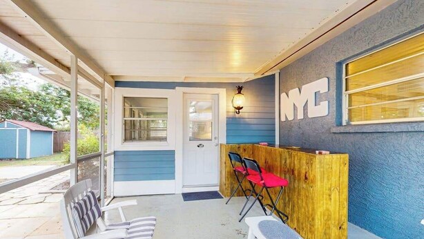 Un portico coperto con posti a sedere, una reception in legno e un cartello con su scritto 'NYC'.