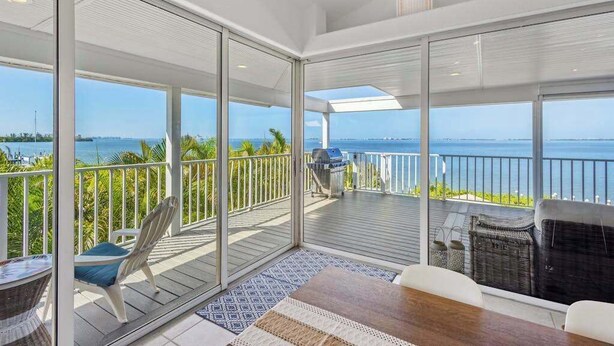Ein Balkon mit Meerblick, einem Grill und Sitzgelegenheiten im Freien.