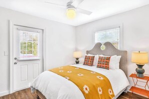 A bedroom with a bed, two bedside lamps, a ceiling fan, and a window with blinds. - Freshly Remodeled Island Suite w Pool & Pet Friendly (Anna Maria)
