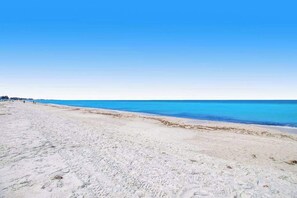 A beach with a clear sky and calm sea. - Waterfront condo with pool and easy access to sugar sand beach (Holmes Beach)